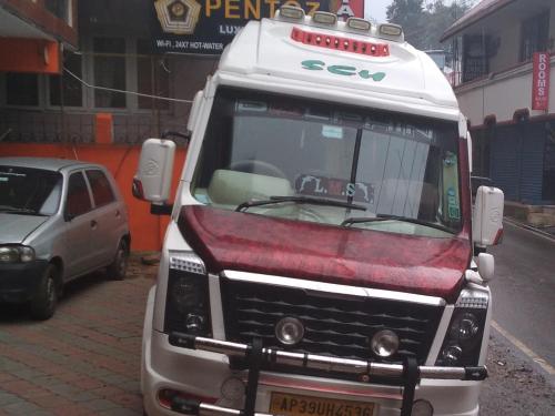 a white truck parked on the side of a street at Hotel PENTOZ - Rose Garden, Ooty in Ooty