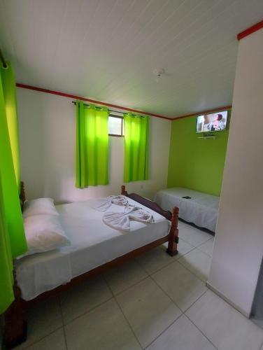 1 Schlafzimmer mit 2 Betten und grünen Vorhängen in der Unterkunft Pousada Sítio Monte Sinai in São José do Barreiro
