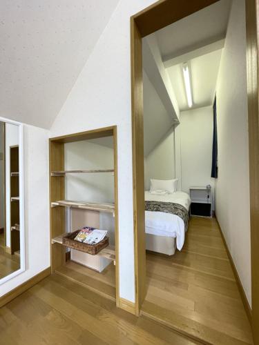 a bedroom with a bed and a mirror at Miyuki Townhouse in Furano