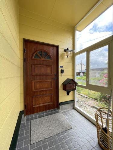 a wooden door in a yellow room with a window at Miyuki Townhouse in Furano