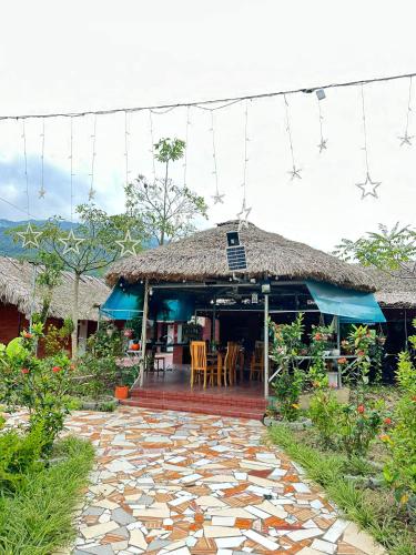 a house with a thatch roof and a patio at Ha Giang Eco Bungalow in Ha Giang