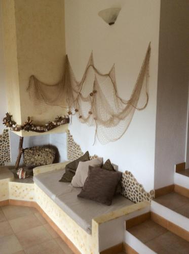 a room with a bed with nets on the wall at Villetta Vista Mare in Costa Paradiso