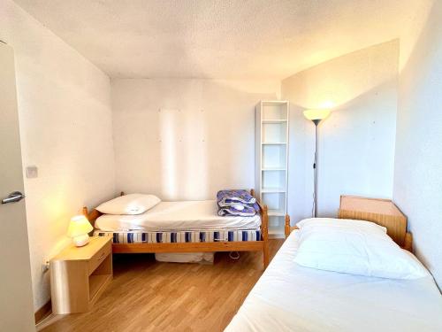 Cette petite chambre comprend deux lits et une échelle. dans l'établissement Appartement T3 à Sète face à la mer avec parking privé, proche plage et commerces - FR-1-338-587, à Sète