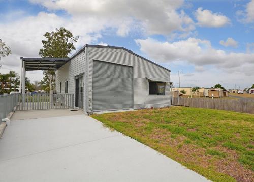 a small gray house with a fence and a yard at Hami's Retreat - Burrum Heads- Close to Boatramp -2BR - Aircon in Toogoom