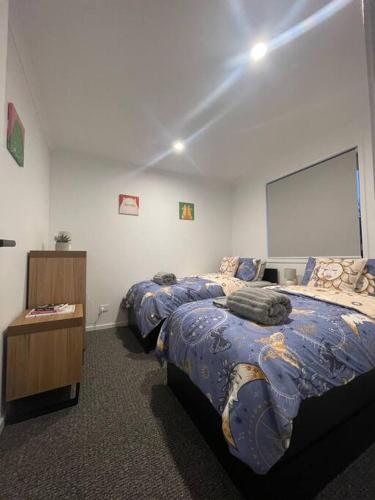 a bedroom with two beds and a white wall at Home in Brighton in Pontville