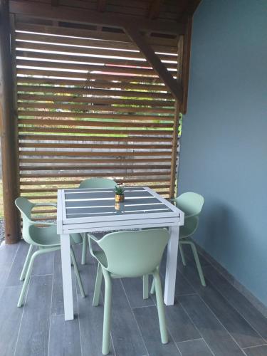 a white table and chairs in a room at Le cosy Valley in Petit-Bourg