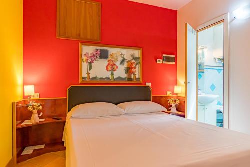 a bedroom with red walls and a white bed at Residence Paolino in Tavernerio