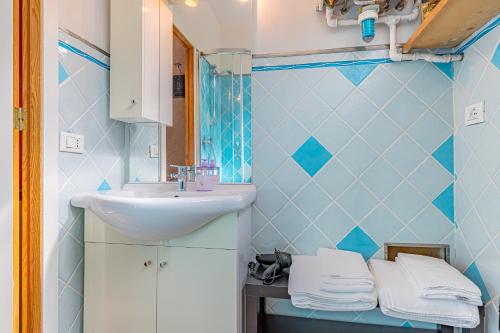 a blue bathroom with a sink and a mirror at Residence Paolino in Tavernerio