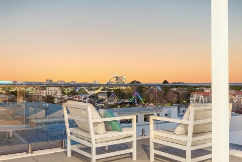 a pair of chairs on a balcony with a view of a city at EAST34/60 - Urban Sanctuary in Perth
