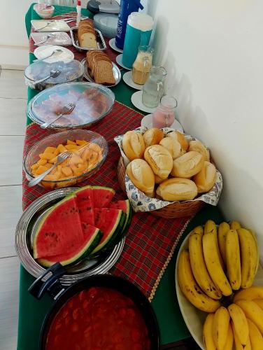 einen Tisch mit Obstschalen und Brotkörben in der Unterkunft Pousada Sítio Monte Sinai in São José do Barreiro