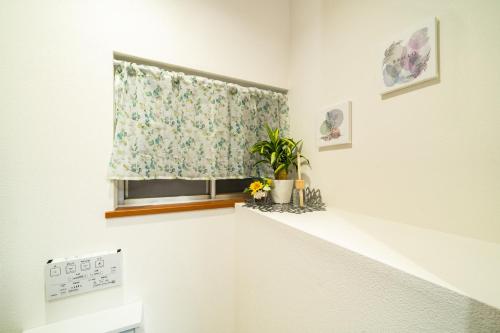 a window with a flower curtain in a room at 93, Yotsugi Seven, Entire house for rent, 四つ木セブン in Tokyo