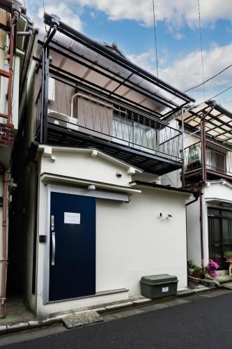a building with a blue door and a balcony at 93, Yotsugi Seven, Entire house for rent, 四つ木セブン in Tokyo