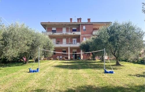a house with a yard with swings in front of it at Lovely Apartment In Tuoro Sul Trasimeno in Tuoro sul Trasimeno