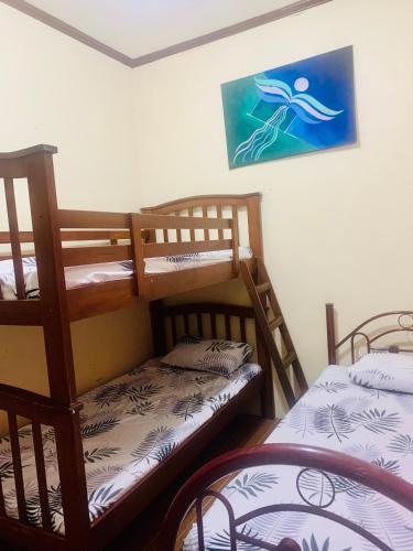 a room with two bunk beds and a picture on the wall at Perlies Inn Balcony House in Tanay