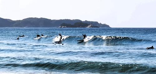 a group of people riding a wave in the ocean at 양철지붕위의 고양이Cat on a Hot Tin Roof in Yangyang