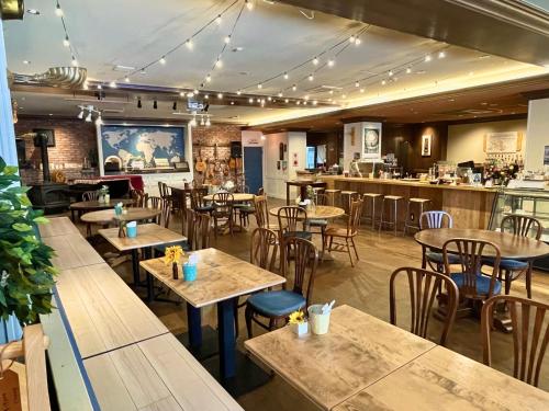 a restaurant with tables and chairs and a bar at Nawate Guesthouse in Matsumoto