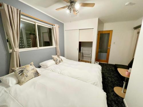 白马村HAKUBA House LuckyStar5 next to shuttle bus station ,711 ,restaurants Modern Chalet的带窗户的房间里有两张白色床