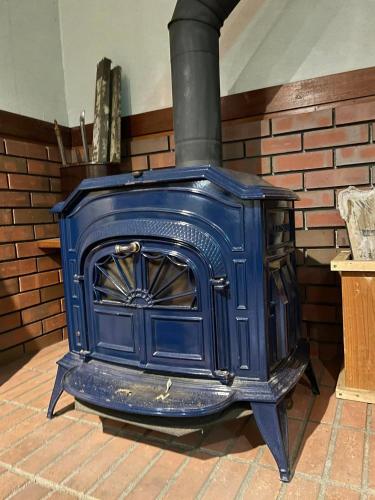 a blue stove sitting on a brick floor at カナリアンホテル in Tateshina