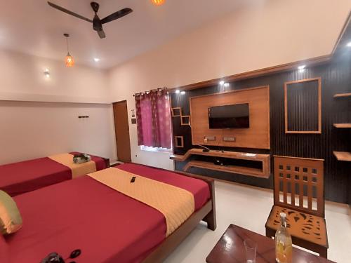a hotel room with two beds and a television at Kanna Garden by Bodhi Bungalows in Kolli Hills