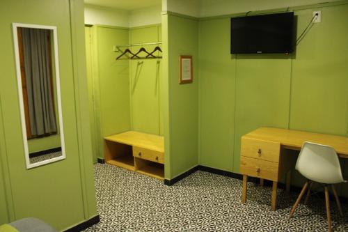 a room with green walls and a desk and a tv at Lu De Anda Hotel Boutique in San Luis Potosí