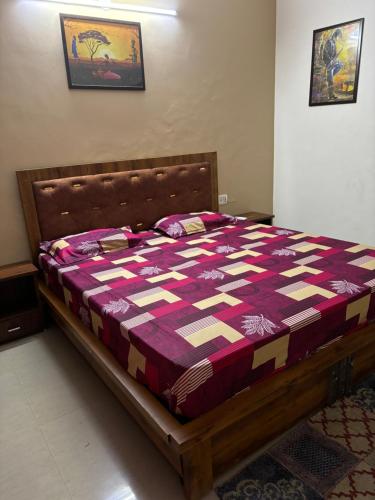 a bed in a bedroom with a purple and white quilt at Yb home in Sonīpat