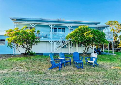 a house with three blue chairs in front of it at Absolute Beachfront Bowen Beach House 3 Bedroom in Bowen
