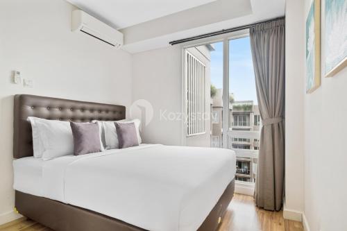 a bedroom with a large bed and a window at Dahayu by Kozystay - Paskal in Bandung