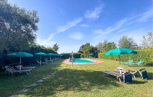 a group of chairs and umbrellas next to a pool at Pet Friendly Apartment in Tuoro sul Trasimeno