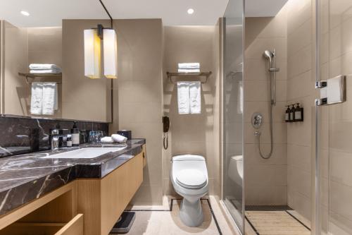 a bathroom with a toilet and a shower and a sink at Xiamen C&D Hotel-Free Welcome Snacks-Oasis Garden in Xiamen