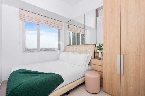 ein Schlafzimmer mit großem Bett und Fenster in der Unterkunft Mukava by Kozystay - Grogol in Jakarta