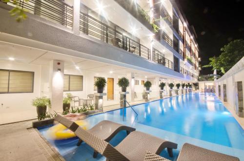 a large swimming pool with chairs in a building at Commander Suites de Boracay in Boracay