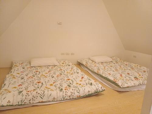 two beds sitting next to each other in a room at 葛萊絲鄉村小屋 Glass Country loft in Hsinchu City