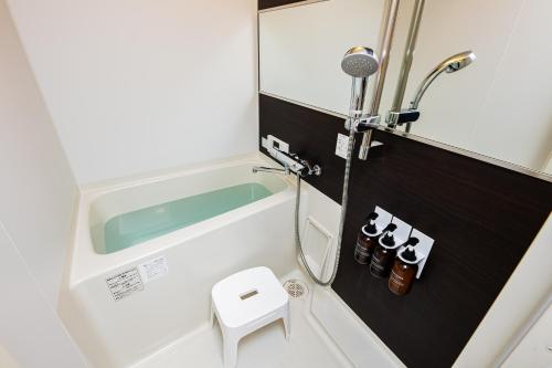 a small bathroom with a shower and a toilet at Presence Hakata in Fukuoka