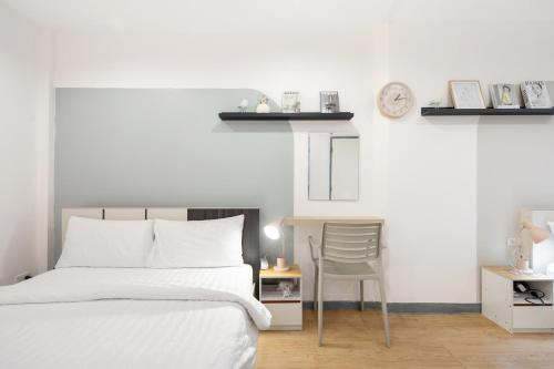 a bedroom with a bed and a chair and a clock at Spacious 4BRTownhouse BTS Onnut 10 Sleeps with Parking in Amphoe Phra Khanong