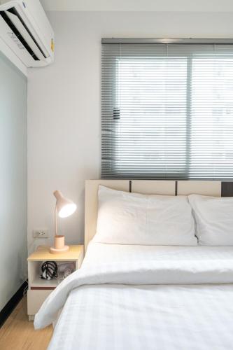 a bedroom with a white bed and a window at Spacious 4BRTownhouse BTS Onnut 10 Sleeps with Parking in Amphoe Phra Khanong