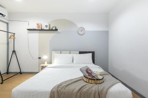 a bedroom with a bed with a book and a basket at Spacious 4BRTownhouse BTS Onnut 10 Sleeps with Parking in Amphoe Phra Khanong