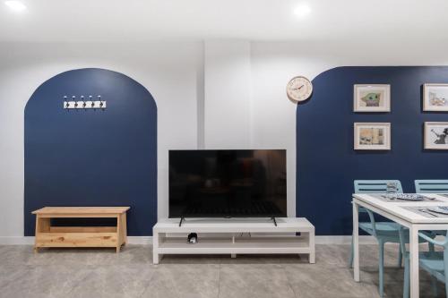 a living room with a tv and a table at Spacious 4BRTownhouse BTS Onnut 10 Sleeps with Parking in Amphoe Phra Khanong