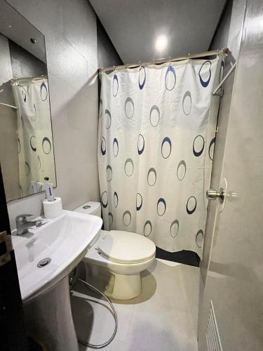 a bathroom with a toilet and a shower curtain at Casita Isla Beach Inn in Boracay