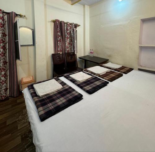 a bedroom with two beds with towels on them at The Golden Lodge Varanasi in Varanasi