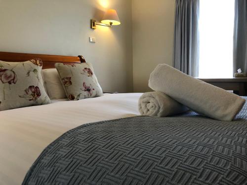 a hotel room with a bed with a towel on it at Douglas Riverside in Port Fairy