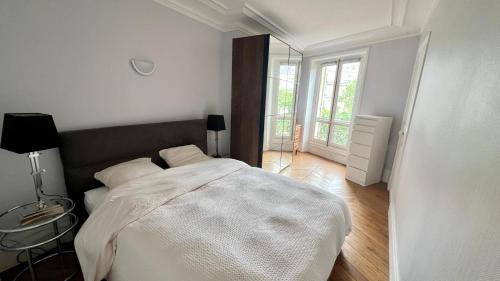 une chambre avec un lit blanc et une fenêtre dans l'établissement Paris 17 Champs-Élysées, à Paris