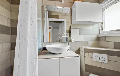 a bathroom with a white sink and a shower curtain at 3 Bedroom Nice Home In Melby in Melby