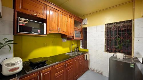 a kitchen with wooden cabinets and a sink at Lotus en Laine Maison de Hanoi - Stunning Full Three Story House with Balcony in Hanoi