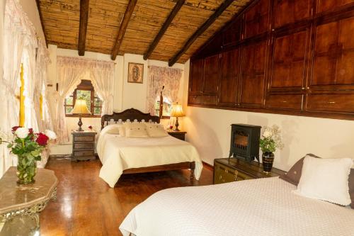 a large bedroom with two beds and a fireplace at Hacienda San Isidro Trails & Experiences in Cotacachi