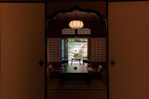a room with a table and chairs and a window at Shoraiso in Yamanouchi