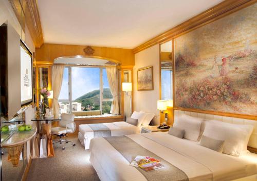 a hotel room with two beds and a window at Regal Hongkong Hotel in Hong Kong