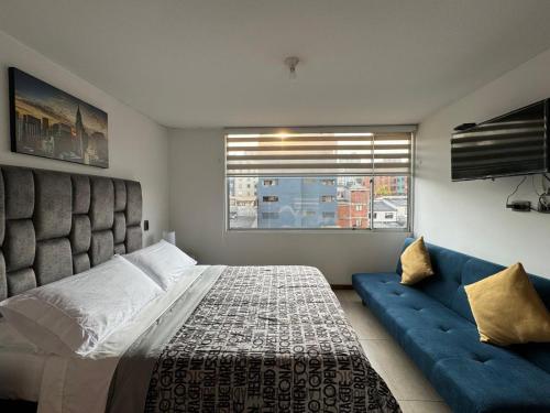 a bedroom with a large bed and a blue couch at MARGARETH in Manizales