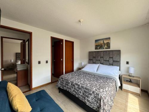 a bedroom with a large bed and a door to a bathroom at MARGARETH in Manizales