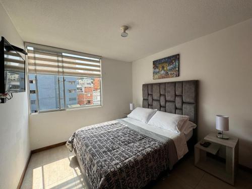 a bedroom with a large bed and a window at MARGARETH in Manizales