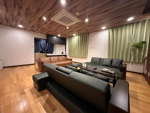 a living room with a couch and a table at Economy Hotel Upashi in Asahikawa